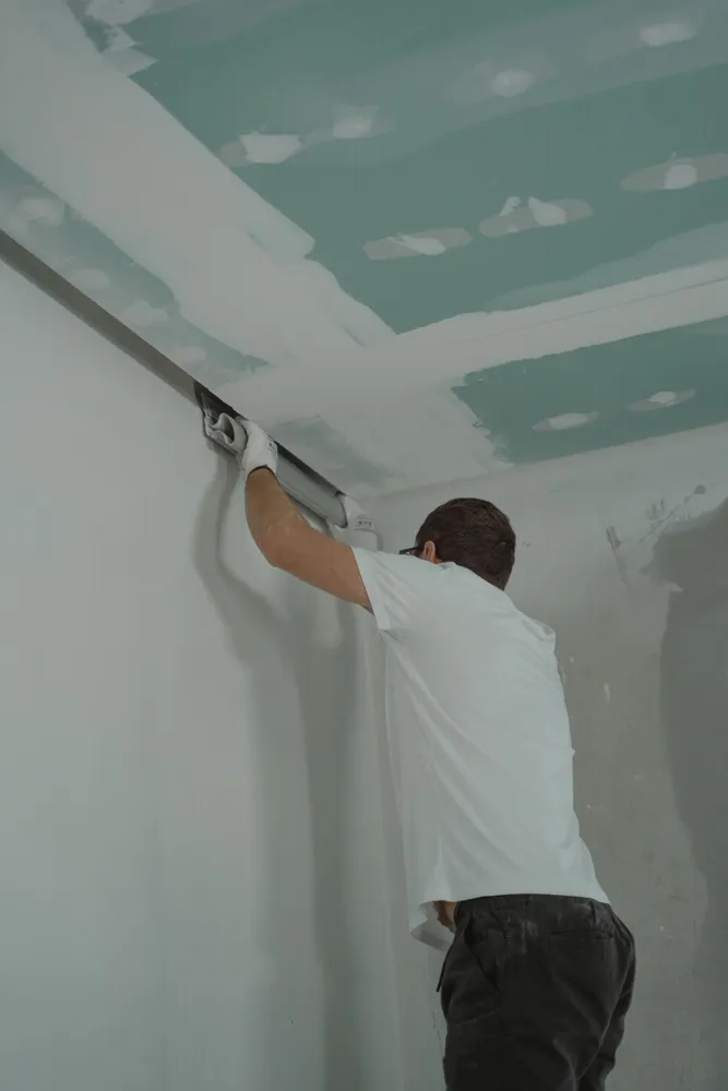 Plâtrier lissant les joints d'un plafond